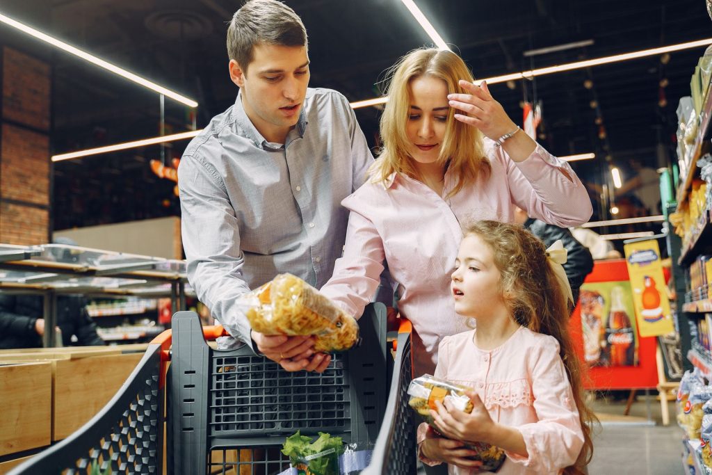 Семья покупает продукты в супермаркете перед выходными