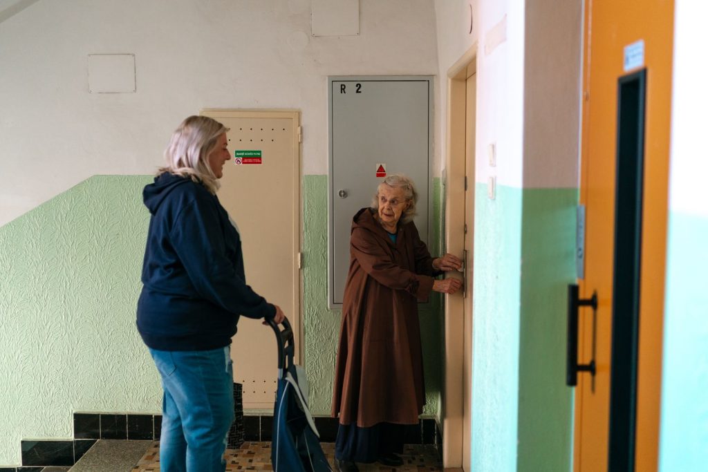 Пожилая женщина общается с помощником